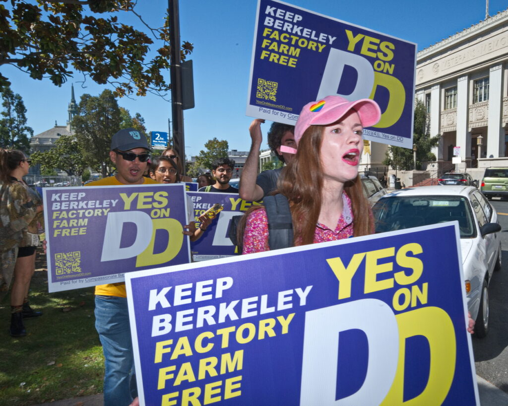 Cassie king holding a keep berkeley factory farm free sign at a rally for measure 6 in Sonoma County